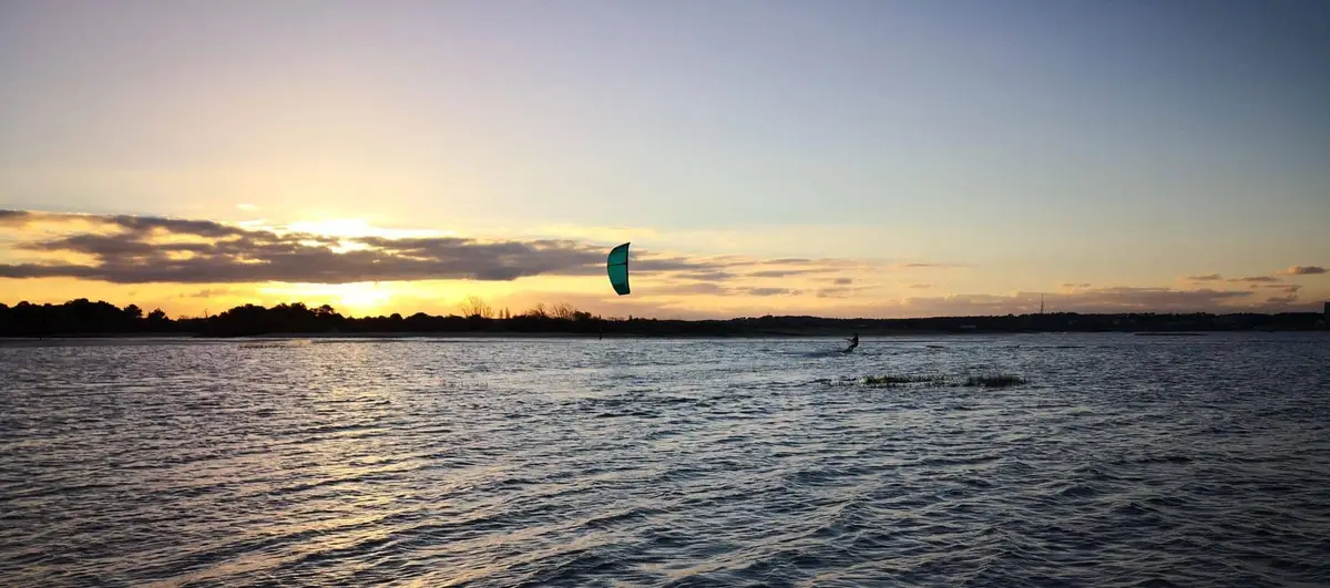 Coucher de soleil sur le bassin d'Arcachon au spot de la Hume, un kite dans le ciel