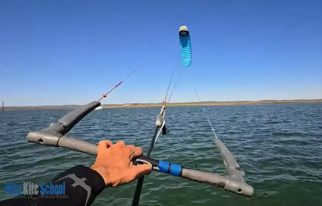 Kitesurfeurs expérimentés naviguant sur un spot observés depuis la plage.