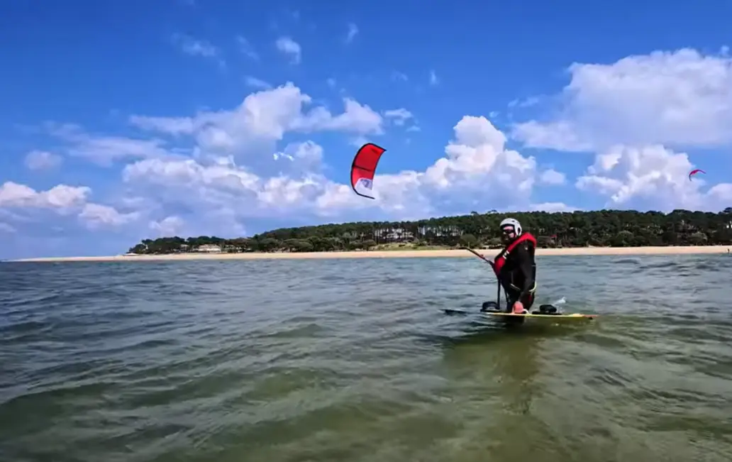 Kitesurfeur évoluant dans une zone peu profonde adaptée aux débutants.
